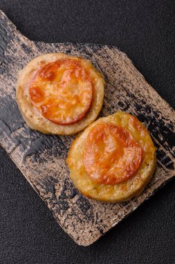 Domates ve peynirle pişirilmiş yuvarlak balık ya da tavuk pirzolası. Tasarımınız için yemek arkaplanı olarak balık pirzolası