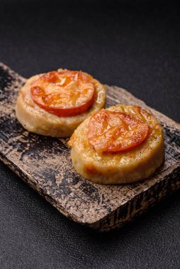 Domates ve peynirle pişirilmiş yuvarlak balık ya da tavuk pirzolası. Tasarımınız için yemek arkaplanı olarak balık pirzolası