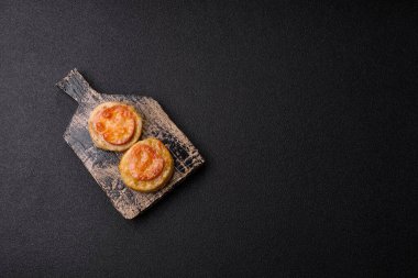 Domates ve peynirle pişirilmiş yuvarlak balık ya da tavuk pirzolası. Tasarımınız için yemek arkaplanı olarak balık pirzolası