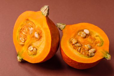 Yarım çiğ balkabağı, olgun turuncu renkli tereyağı kabağı. Tasarımınız için yemek arkaplanı olarak çiğ balkabağı