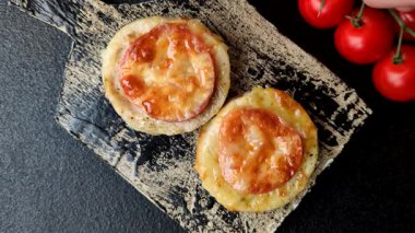 Domates ve peynirle pişirilmiş yuvarlak balık ya da tavuk pirzolası. Tasarımınız için yemek arkaplanı olarak balık pirzolası