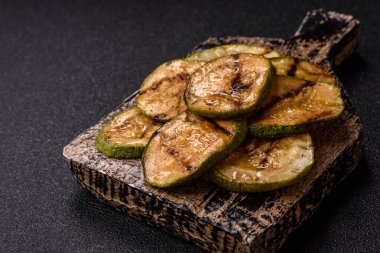 Izgara yeşil kabak dilimleri, vejetaryen yemekleri. Tasarımınız için yemek arkaplanı olarak yeşil barbekü kabağı