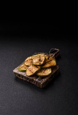 Izgara yeşil kabak dilimleri, vejetaryen yemekleri. Tasarımınız için yemek arkaplanı olarak yeşil barbekü kabağı