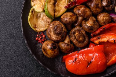 Izgara sebze, dolmalık biber, mantar ve kabak soslu sağlıklı vejetaryen yemeği. Tasarımın için yemek arkaplanı olarak bir tabakta ızgara sebze..