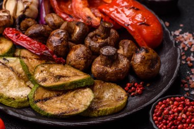 Izgara sebze, dolmalık biber, mantar ve kabak soslu sağlıklı vejetaryen yemeği. Tasarımın için yemek arkaplanı olarak bir tabakta ızgara sebze..
