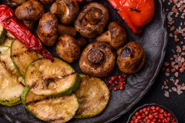 Izgara sebze, dolmalık biber, mantar ve kabak soslu sağlıklı vejetaryen yemeği. Tasarımın için yemek arkaplanı olarak bir tabakta ızgara sebze..