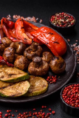 Izgara sebze, dolmalık biber, mantar ve kabak soslu sağlıklı vejetaryen yemeği. Tasarımın için yemek arkaplanı olarak bir tabakta ızgara sebze..