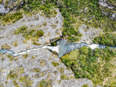 Cotopaxi 'de doğan ve volkanik kayalardaki bir kanaldan geçen kristal sudan oluşan şelale.
