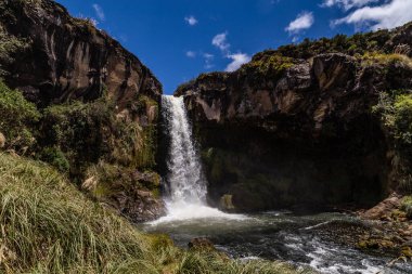 Cotopaxi 'de doğan ve volkanik kayalardaki bir kanaldan geçen kristal sudan oluşan şelale.