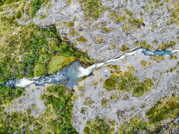 Cotopaxi 'de doğan ve volkanik kayalardaki bir kanaldan geçen kristal sudan oluşan şelale.