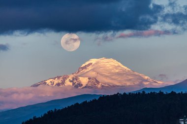 Güneş batarken Cayambe volkanı bir tarafta Quito, Ekvador 'dan görülüyor.