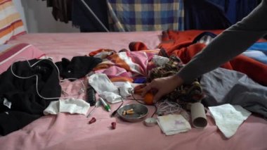 Kirli ve dağınık bir yatak odası. Kirli ve bakımsız bir eve dağınık çeşitli eşyalar serpiştirilmiş yataklar. Ev temizliği ve kişisel refah. Kül tablası, yanmamış sigara ve nesneler.