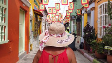 Kolombiya, Cartagena de Indias 2022 - Güney Amerika 'daki eski İspanyol sömürgesi Unesco Heritage kasabası Cartagena' nın sokaklarında yürüyor. Getsemani bölgesinde şapkalı bir bayan.