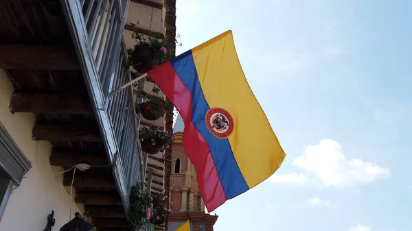 迎风飘扬的哥伦比亚国旗和经典的西班牙殖民阳台 — 图库照片