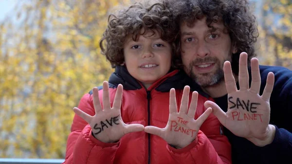 father and son child - Hand with written Save the planet - Global warming and climate change concept - air pollution of the air due to the heating of the houses - lifestyle in family during earth day
