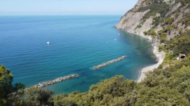 Liguria, Cinque Terre, Framura 'nın insansız hava aracı görüntüsü inanılmaz mavi deniz ve plajlı bir deniz köyü - Kuzey İtalya' da yaz tatili - kıyıları korumak için kaya bariyeri - deniz seviyesini yükseltiyor
