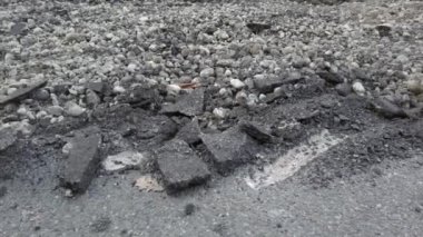 Parçalanmış asfalt yol parçalarının yakın çekim görüntüleri. 