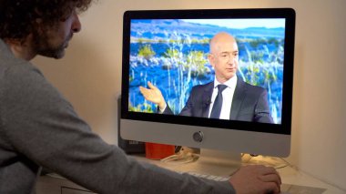 Europe, Milan 2022 - Watching Television News in a laptop computer - Jeff Bezos interview