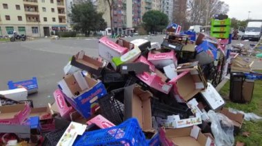 Europe, Italy , Milan 2022 - Giambellino poor neighborhood in suburbs, fruit vegetable market in the street and poor people look for food among the waste of the stalls - economic crisis and poverty