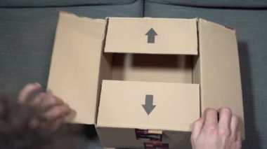 Europe, Italy , Milan January 2023 - unboxing of Amazon delivery pack -  home delivery and home opening on sofa