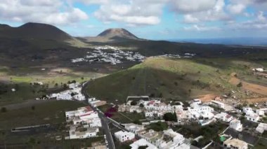 Spain, Lanzarote, Canary - Drone aerial view of Piscinas Naturales de Punta Mujeres with white houses and volcano by the sea ocean - summer journey in biosphere reserve in north of Lanzarote island