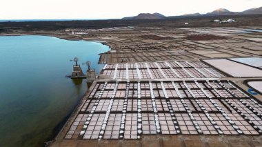 Spain - Drone aerial view of Janubio salt flats mines (Playa del Janubio) in Lanzarote are the largest in the Canary Islands - salt production, pools of seawater dry in the sun, tourist attraction