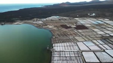 Spain - Drone aerial view of Janubio salt flats mines (Playa del Janubio) in Lanzarote are the largest in the Canary Islands - salt production, pools of seawater dry in the sun, tourist attraction