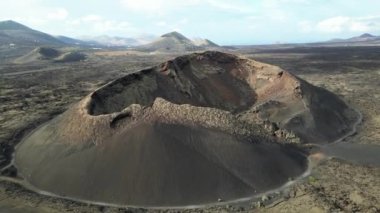 aerial drone view of black lava fields after volcano eruption in volcanic landscape on a Lanzarote island in Spain at Canary Islands, Timanfaya national park biosphere reserve Unesco