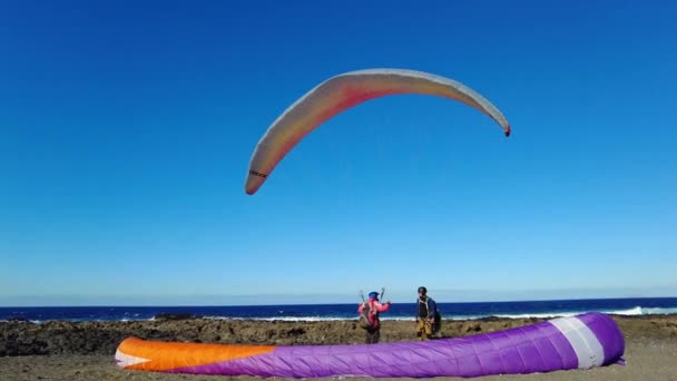 スペイン ランサローテ ファマラビーチ パラグライダーは存在下で無料のフライトの最も簡単で軽量な手段です 男は海のビーチで風を待つ — ストック動画