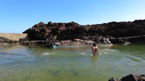 Uomo Nuota Gioca Con Acqua Una Piscina Naturale Vicino Mare — Video Stock