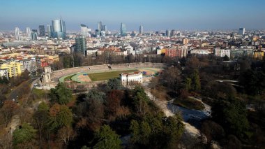 EUROPE, ITALY MILAN 2023 - Drone aerial view  in Sempione park - Arena old soccer Stadium  and the new skyline of the city in downtown - Old architecture and new modern skyscrapers in Gae Aulenti 