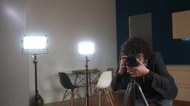 Oturma odasında fotoğraf çeken erkek fotoğrafçı - ev fotoğrafı ve evi satmak için profesyonel video - iç tasarım ve ev dekorasyonu