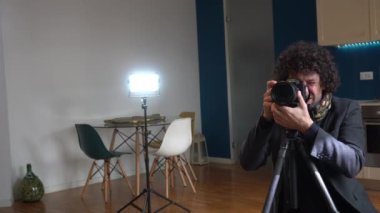 Oturma odasında fotoğraf çeken erkek fotoğrafçı - ev fotoğrafı ve evi satmak için profesyonel video - iç tasarım ve ev dekorasyonu