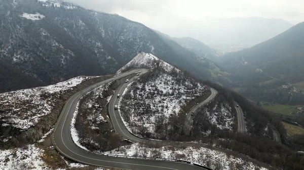 Zambla pass is a mountain pass in Orobie Pre-Alps Selvino, province of Bergamo, which connects the Serina and Parina valleys, Curved mountain road with hairpin bends and cars in a winter snowy