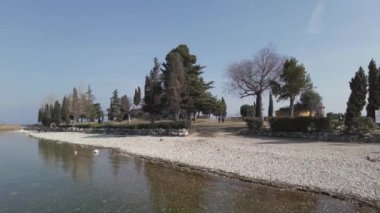 İtalya, Garda Gölü 2023, San Biagio Adası, Tavşan Adası - gölün sığ suları yürüyerek ve adaya ulaşmanızı sağlar - suda acil durum, kuraklık ve kuraklık, su seviyesi düşük 