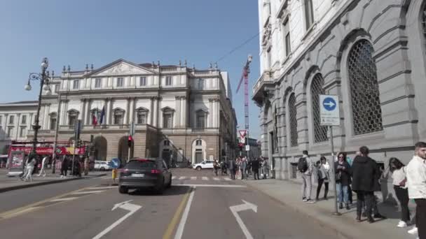 ヨーロッパ イタリア ミラノ2023 観光客や人々の群衆がダウンタウンを訪問 自転車で観光を楽しむことによって観光ツアーを取る Piazza Della Scalaオペラ 赤い都市バス — ストック動画