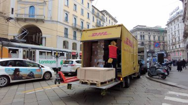 Avrupa, İtalya, Milan 2023 - Covid-19 Coronavirus karantina evinden sonra şehir merkezine DHL sarı kamyon teslimatı