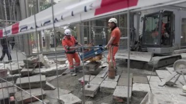 Avrupa, İtalya, Milano 2023 - Şehir merkezinin sokaklarını güzelleştirmek için taş levhalarla kaldırım döşenmiş yol yeniden inşa çalışmaları ve kaldırımları olan bir inşaat sahası - dayanıklılık planı için devlet kamu hizmetleri 