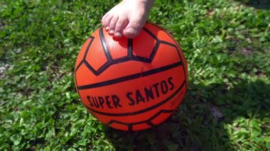 İtalya 2023 - Eski turuncu futbol topu Super Santos - yeşil bir bahçede çocukken futbol oynuyor