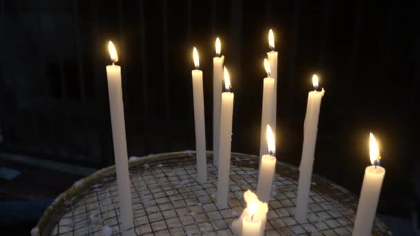 礼拝と信仰の希望の印として信者によって教会に灯されたキャンドル 教会でろうそくを灯し 教会へのチャリティーや供物を行う — ストック動画