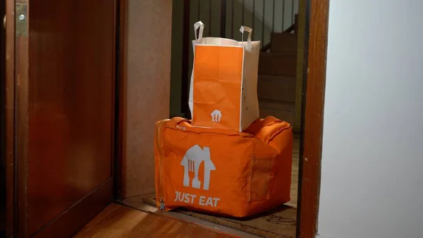 Avrupa, İtalya, Milano 2023 - Sadece yemek dağıtımı adamın akşam yemeği için hazır olduğu daireye varır - kapının dışındaki iskelede eve teslim