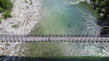 Alagna Val Sesia Piedmont Alp Dağları 'ndaki insansız hava aracının görüntüsü ile nehir kıyılarına katılan tahta Tibet asma köprüsünün üzerinden insansız hava aracı uçuşu macera yolculuğunda konsept yolculuk.