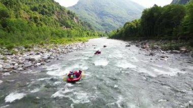 Val Sesia Alagna Piedmont Alpleri 'ndeki kanyonun doğası ve derenin akıntısına batmış botlarla nehirde rafting yapmak yaz su sporları aktivitelerinin insansız hava aracı görüntüsüdür.
