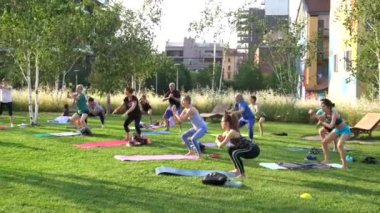 Avrupa, İtalya, Milano 06-20-2023 - insanlar Bam Giardino degli Alberi Garibaldi 'de bir parkta yoga meditasyon dersi veriyor - yaz tatillerinde jimnastik ve spor aktiviteleri ve diyet yapıyorlar