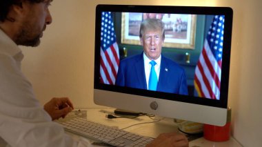 Avrupa, Milan 2023 - Rusya ile Ukrayna arasındaki savaş hakkında dizüstü bilgisayarda TV Haberleri İzleyen Donald Trump başkanı Usa Amerika ulusuna konuştu