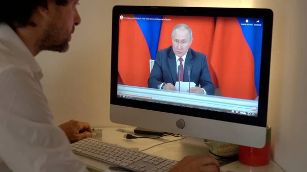 Avrupa, Milan 2023 - Rusya ile Ukrayna arasındaki savaş hakkında dizüstü bilgisayarında televizyon haberleri izlemek - Putin ulusa sesleniyor