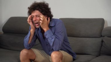Kanepede başı ağrıyan bir adam