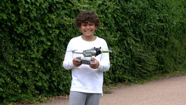 9岁的男孩与无人机一起玩耍和飞行 梦想着在童年时期飞行 学会了带着执照安全地使用无人机 — 图库照片