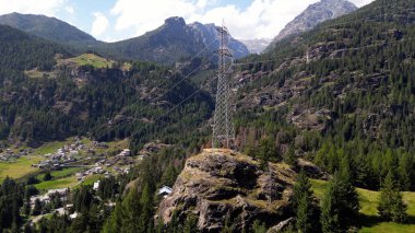 Dağlardaki yüksek voltajlı elektrik direğinin insansız hava aracı görüntüsü - yenilenebilir elektrikle doldurulan dağ köyünün insansız hava aracı görüntüsü - Alpe Geria, Sondrio, İtalya, Avrupa