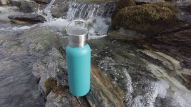 Su şişesini bir dağ deresinde doldurmak - nehirde buzul çözülmesi ve içme suyu - plastik kullanım yok ve çevre için çevre dostu tercih - Gezegeni Kurtarın